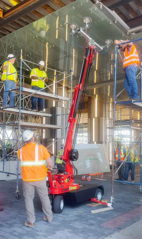four glaziers on job with glass lifter