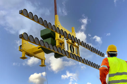 construction worker looks up at jumbo-sized glass lifter