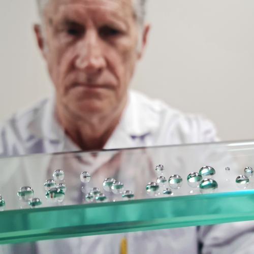 man holding glass with beaded water drops on its surface